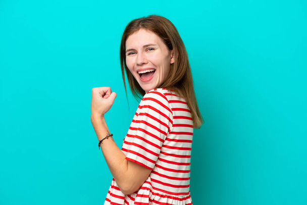 Young English woman isolated on blue background celebrating a victory - Photo, Image