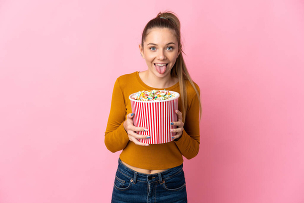 Young Lithuanian woman isolated on pink background holding a big bucket of popcorns - Fotoğraf, Görsel