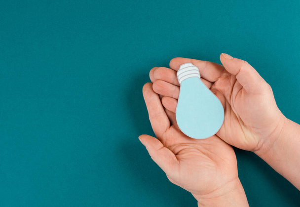 hand holding a blue pill box on a green background. - Φωτογραφία, εικόνα