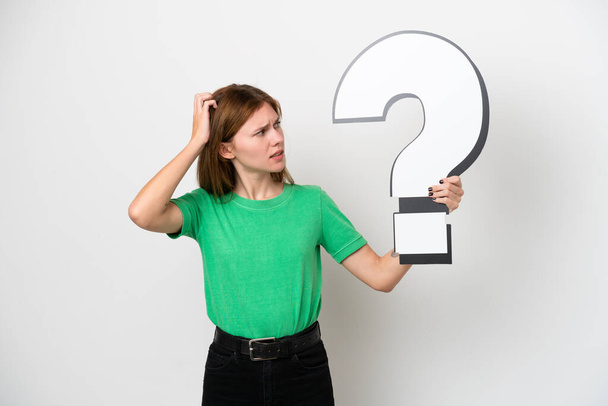 Young English woman isolated on white background holding a question mark icon and having doubts - Fotó, kép