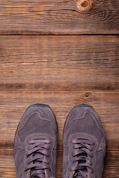 Men sneakers on a wooden background. - Фото, изображение