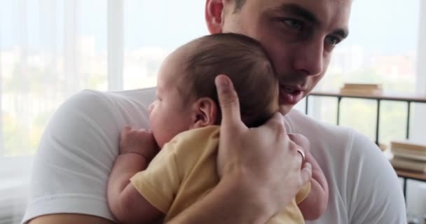 Молодий батько заспокоює свого плачучого сина
 - Кадри, відео