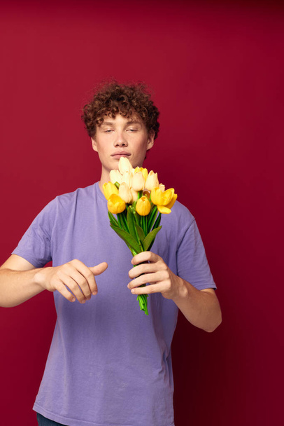 cute teen holding a yellow bouquet of flowers purple t-shirts isolated background unaltered - Foto, Imagen