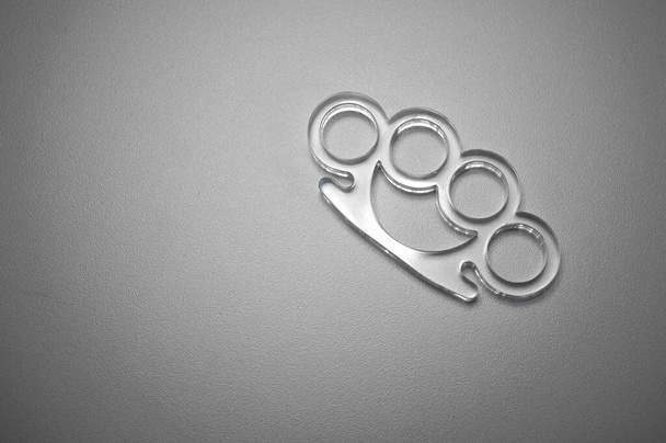 Plastic transparent brass knuckles on white isolate. Cutting on plexiglass.Manufacture of plastic parts. - Foto, afbeelding