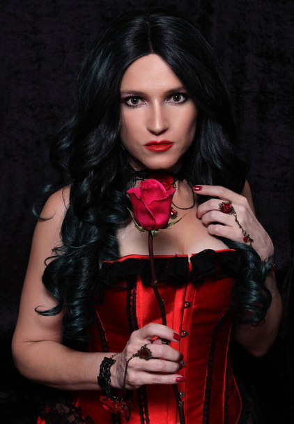 Γυναίκα με κόκκινο κορσέ με κόκκινο τριαντάφυλλο - Φωτογραφία, εικόνα