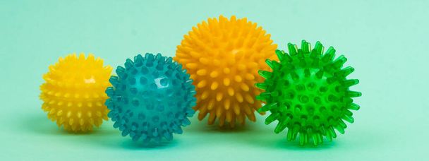 colored massage needle balls of different sizes on a turquoise background, the concept of prevention of flat feet, hallux valgus, banner - Foto, Imagem