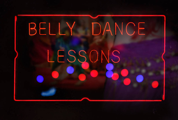Lecciones de danza Neon Belly Neon SIgn en ventana húmeda lluviosa - Foto, imagen