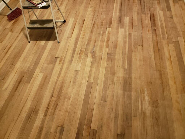 Een houten vloer die is geschuurd ter voorbereiding op het lakken - Foto, afbeelding