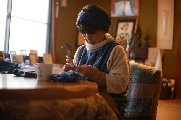 Female hand-knitting neck warmer  - Valokuva, kuva
