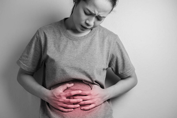 Woman having painful stomach ache. Young woman with abdominal pain due to menstruation. Abdominal pain due to gastritis. - Φωτογραφία, εικόνα