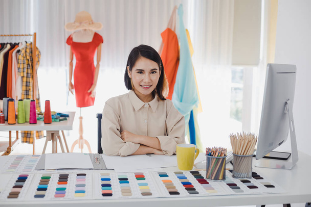 Retrato de mujer de ropa de diseñador asiático en la mesa de trabajo en la oficina con negocio de éxito. Concepto de diseñador de inicio. Diseñadores de ropa están trabajando en el estudio. - Foto, imagen