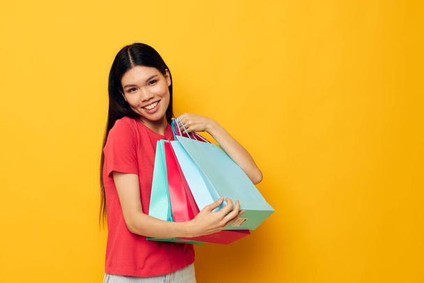 Charming young Asian woman with colorful bags posing shopping fun Lifestyle unaltered - 写真・画像