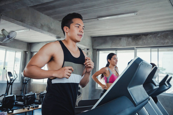 Young handsome on modern electric treadmills at the gym. Running on treadmill. - Фото, зображення