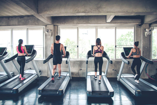 Group of athletes running on electric treadmills at modern gym. People jogging on treadmills. - Foto, Imagen
