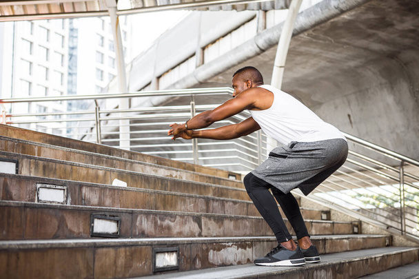 Corredor en forma joven afroamericano entrenando arriba en el estadio. Guapo joven ejercicio al aire libre. - Foto, Imagen