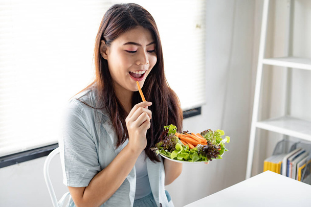 Koncepcja diety przez jeść zdrową sałatkę. Młoda kobieta trzyma warzywa naczynia dla zdrowej diety z uśmiechem w służbie zdrowia. - Zdjęcie, obraz