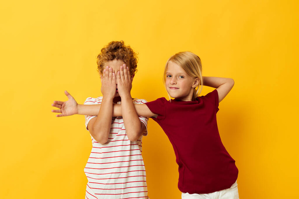 Boy and girl casual wear games fun together yellow background - Foto, Bild