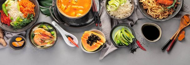 Asiatische Gerichte auf grauem Hintergrund. Traditionelles Essen kokettiert. Draufsicht, flache Lage, Kopierraum, Panorama - Foto, Bild