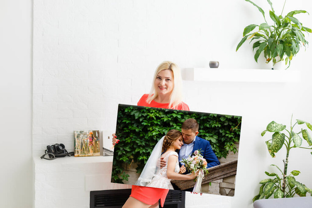 Woman holding wedding photography photo canvas print with gallery wrap. - 写真・画像