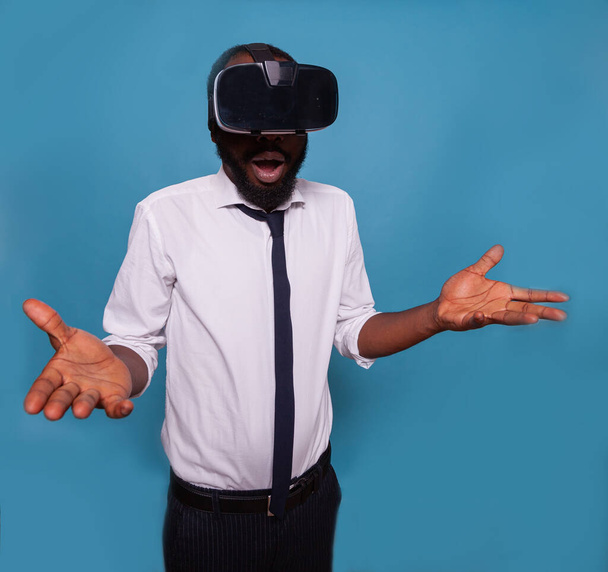 Portrait of surprised man wearing virtual reality goggles having futuristic experience - Foto, Bild
