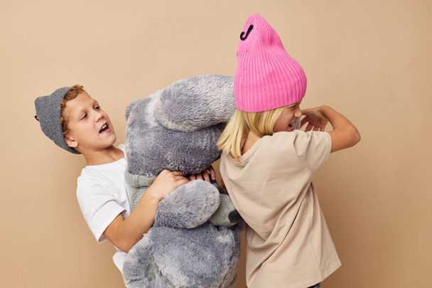Photo of two children in hats with a teddy bear friendship Lifestyle unaltered - Foto, Imagem