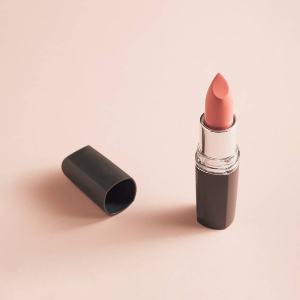 Gentle coral lipstick on soft pink background - Φωτογραφία, εικόνα