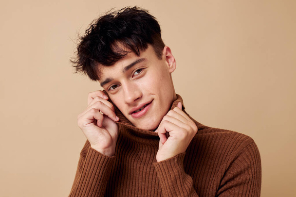 portrait of a young man brown turtleneck posing fashion light background unaltered - 写真・画像