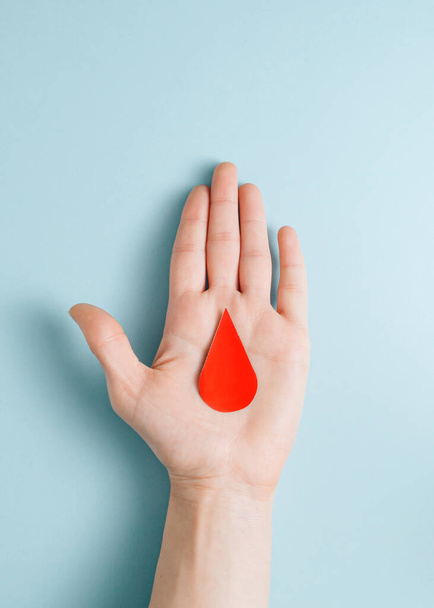 Minimalist concept of a red drop of blood on the palm - Fotoğraf, Görsel