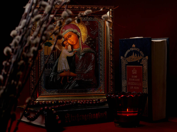 The icon of the Mother of God "The Seeking of the Pogmbs" and books with inscriptions in Russian "Prayer Book" and in German "Book of Church Hymns" - Fotoğraf, Görsel