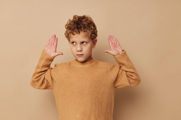 Cute little boy in a beige sweater posing fun childhood unaltered - Photo, Image