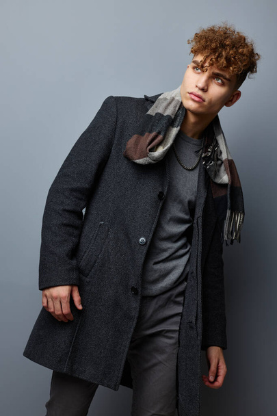 kinky guy in a coat a checkered scarf Lifestyle unaltered - Valokuva, kuva
