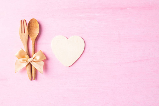 Couple spoon and fork with ribbon and heart shape on pink background, Valentine day concept - Fotografie, Obrázek