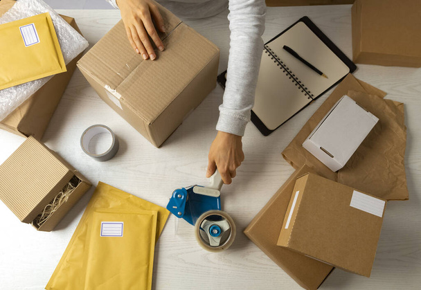Donna inviare il pacco in una scatola da un servizio di consegna - Foto, immagini