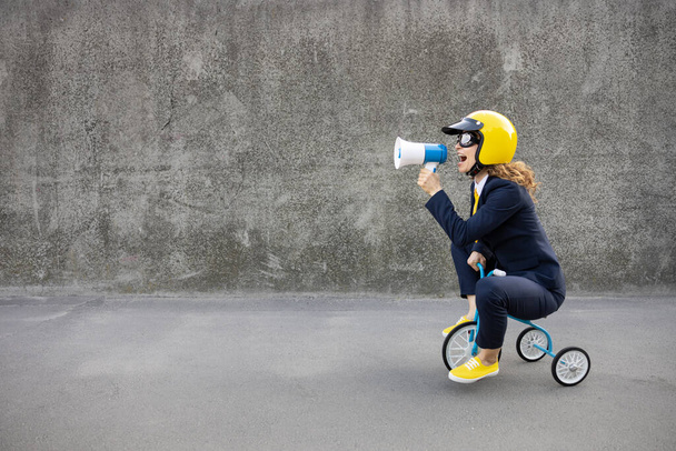 Happy businesswoman going to work. Funny young woman riding retro bike outdoor. Person shout through loudspeaker. Back to work, start up and business idea concept - Fotoğraf, Görsel