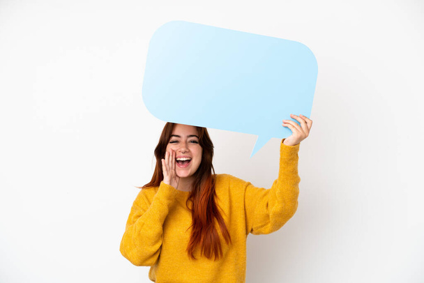 Young redhead woman isolated on white background holding an empty speech bubble and shouting - Foto, Bild