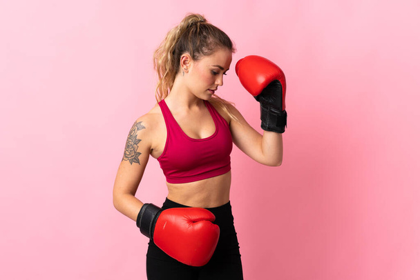 Young Brazilian woman isolated on pink background with boxing gloves - Fotó, kép