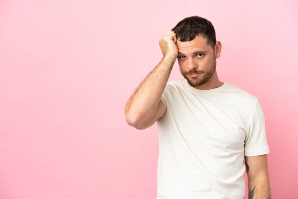 Young Brazilian man isolated on pink background with an expression of frustration and not understanding - Foto, afbeelding