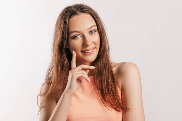 Beautiful young girl smiling and posing looking at the camera on a white isolated background. Positive brunette woman. Kind look. Beauty face. - Fotó, kép