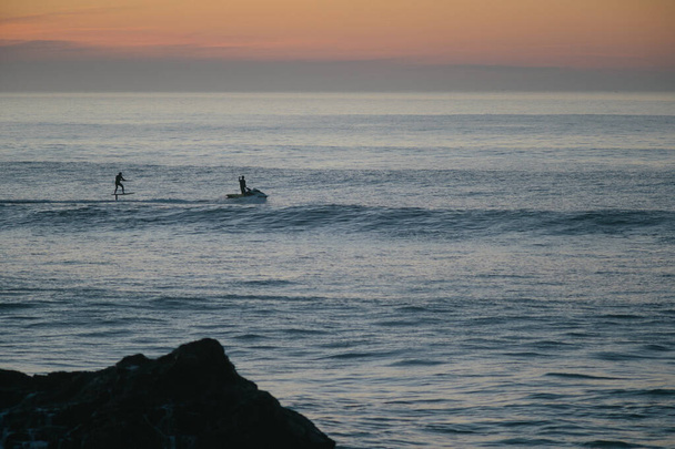 Jet ski towing a foil surfer during the sunset on atlantic ocean - Photo, Image