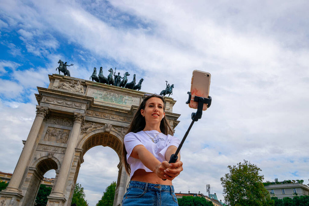 Travel influencers Milan island. Paint building house in Europe Milano. Photographer blogger girl with smartphone in Piazza del Duomo, Cathedral Square. Traveling and freelancing, modern lifestyle - Foto, Bild
