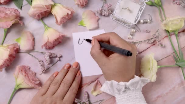 Rukama píšu ANO I DO card near flowers close up on a mramor table - Záběry, video