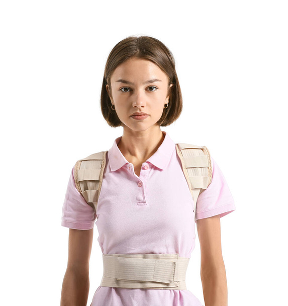 Young woman in back brace on white background - Zdjęcie, obraz