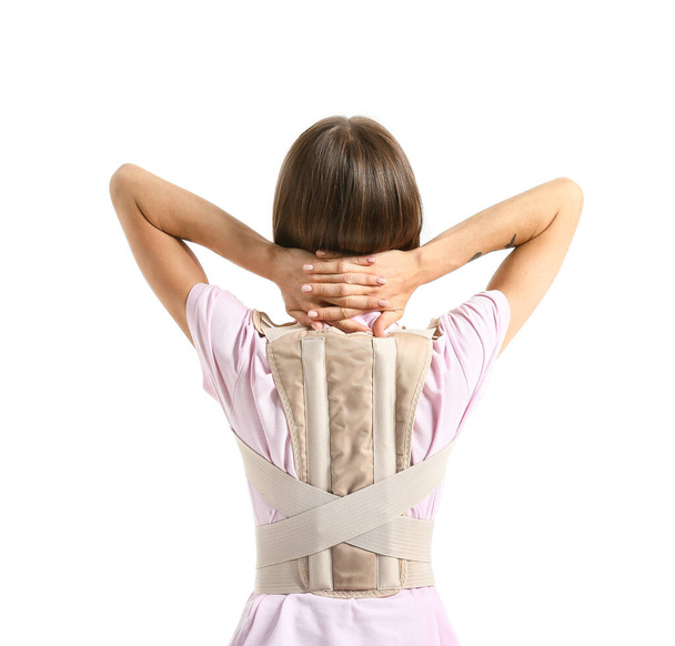 Young woman in back brace on white background - Foto, Bild