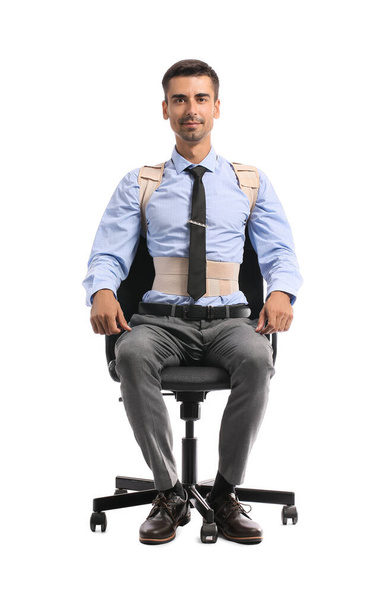 Üzletember hátmerevítős ül széken ellen fehér háttér - Fotó, kép
