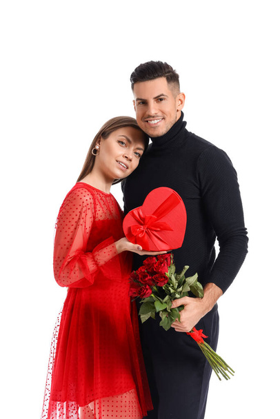 Happy young couple with gift and flowers on white background. Valentine's Day celebration - Fotografie, Obrázek