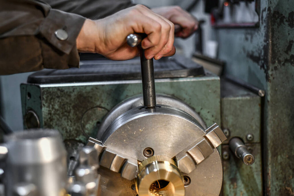 The work turner clamps the bronze parts in the jaws of the lathe chuck. - Photo, Image