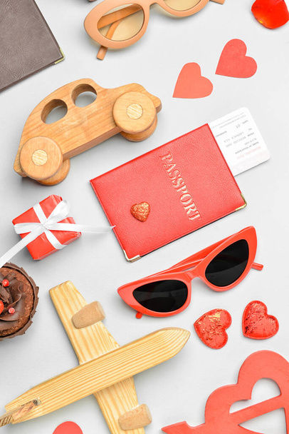 Hermosa composición para el Día de San Valentín con juguetes de madera, regalo, gafas de sol y corazones sobre fondo claro - Foto, Imagen