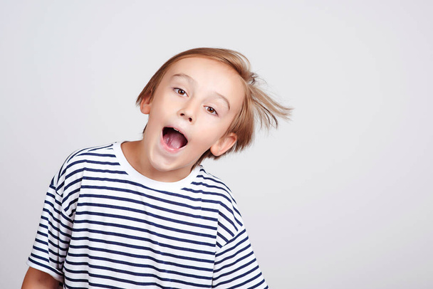 Joyful child having fun. Funny boy grimacing face over white background. Shocked boy posing at studio. Children style and fashion. Face emotion and expression. - Foto, immagini