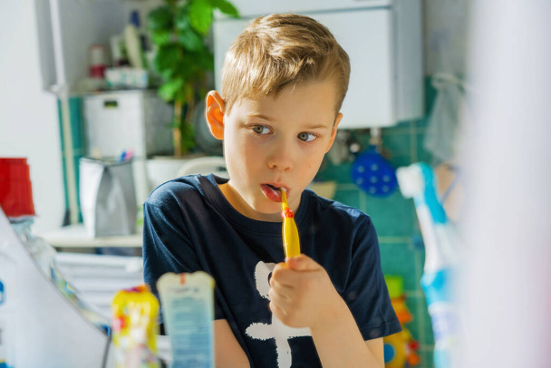 A boy brushes his teeth early morning. Bathroom. - Fotó, kép