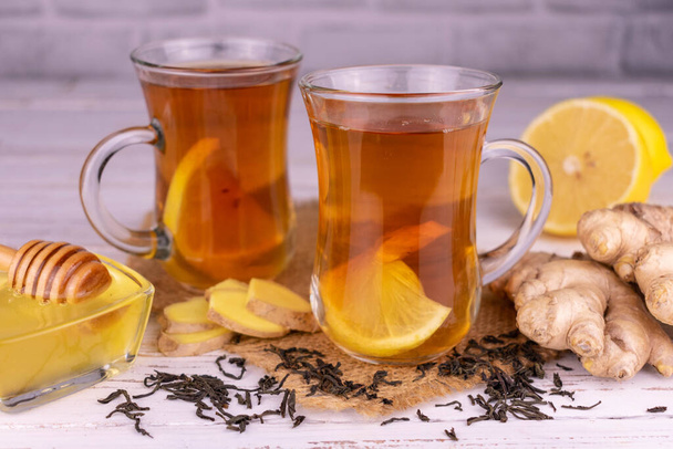 Ginger-lemon tea with honey in transparent cups on a white background. - Fotoğraf, Görsel